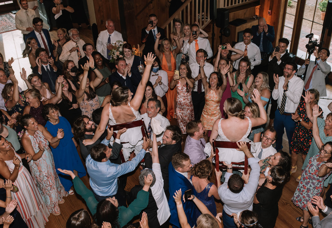 NH WEDDING DJ PARTY with two brides lifted up in the air on chairs